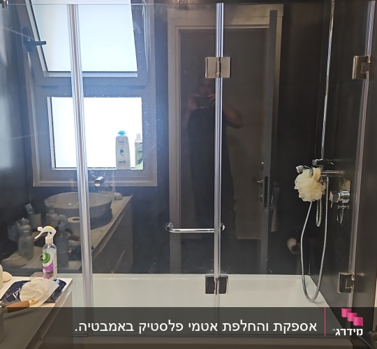מקלחת עם דלת זכוכית, ראש מקלחת וספוג רחצה